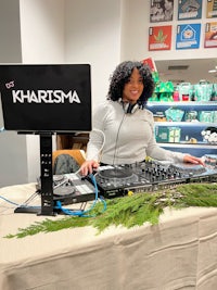 a woman djing in front of a christmas tree